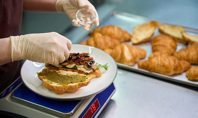 close up view baker adding sliced olives on half o 2024 10 18 11 50 59 utc