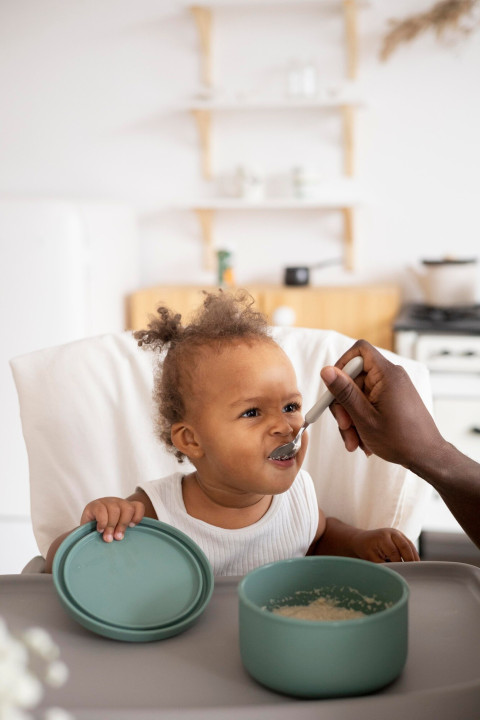 Making Mealtime Fun: Creative Ways to Introduce New Foods to Kids 42 father feeding his little baby girl kitchen 23 2149125812