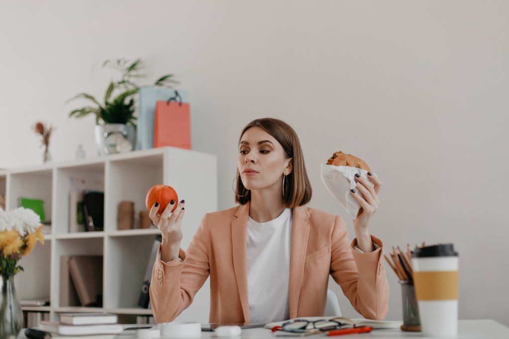 Sustainable Weight Loss: Habits That Actually Work Long-Term 43 female manager posing white office lady looks apple reluctantly wanting eat burger 197531 10715