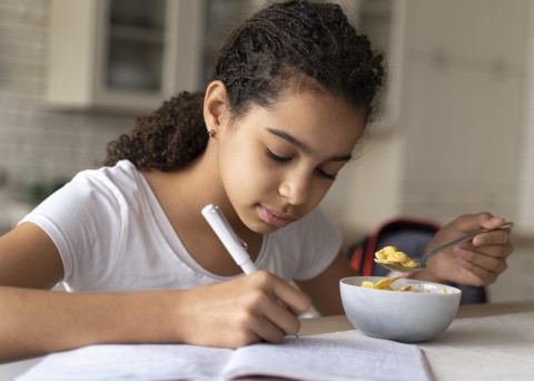 The Prep 89 girl doing her homework while having breakfast