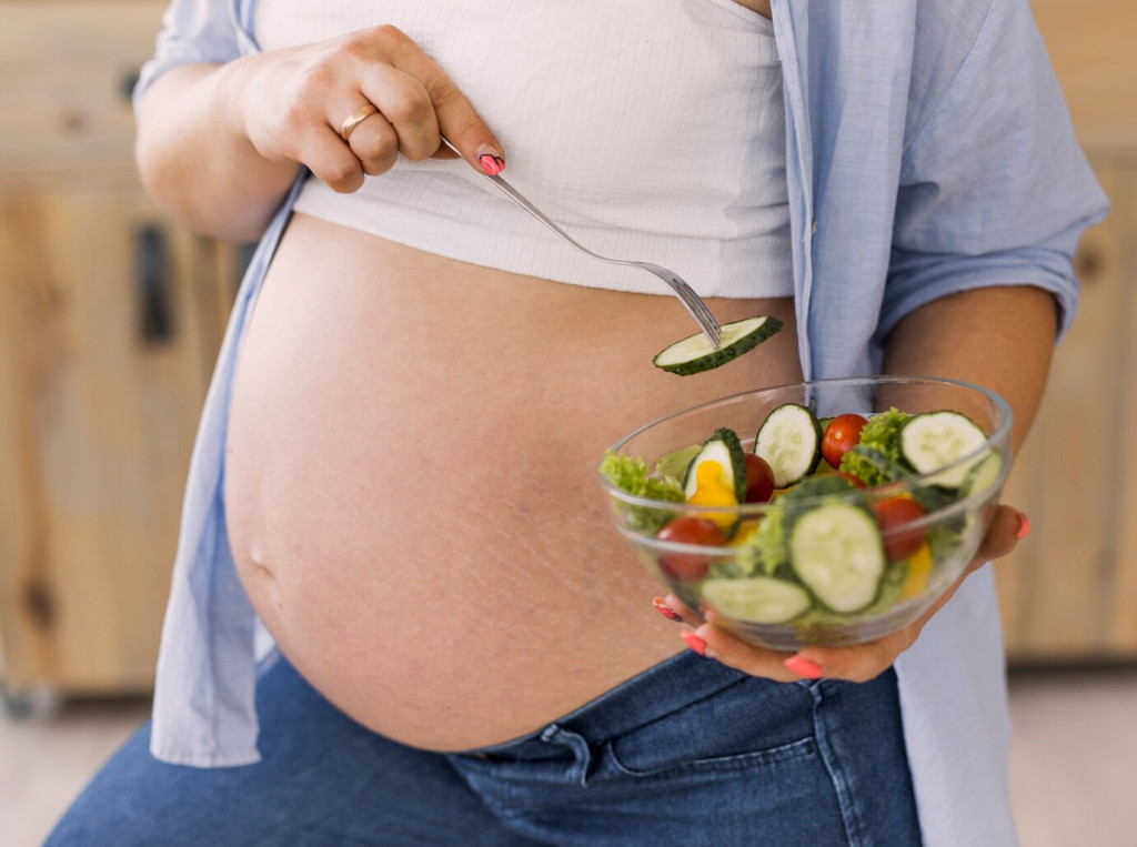 what-to-avoid-during-pregnancy-foods-and-habits-to-skip 43 pregnant woman holding bowl salad 23 2148301955