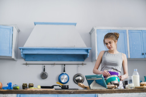 woman looking tablet mixing ingredients